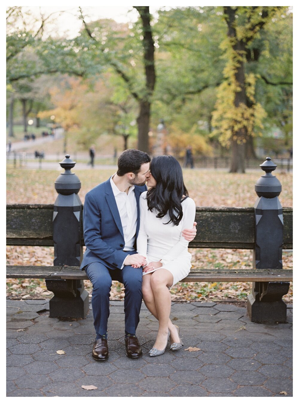  Fall engagement photos in central park couple sitting on a bench kissing 